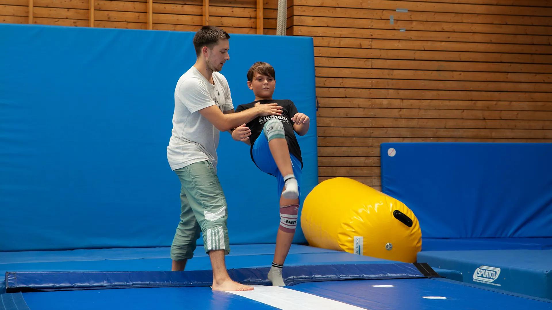 Trainer hilft bei einem Sprung — WEMOVE.