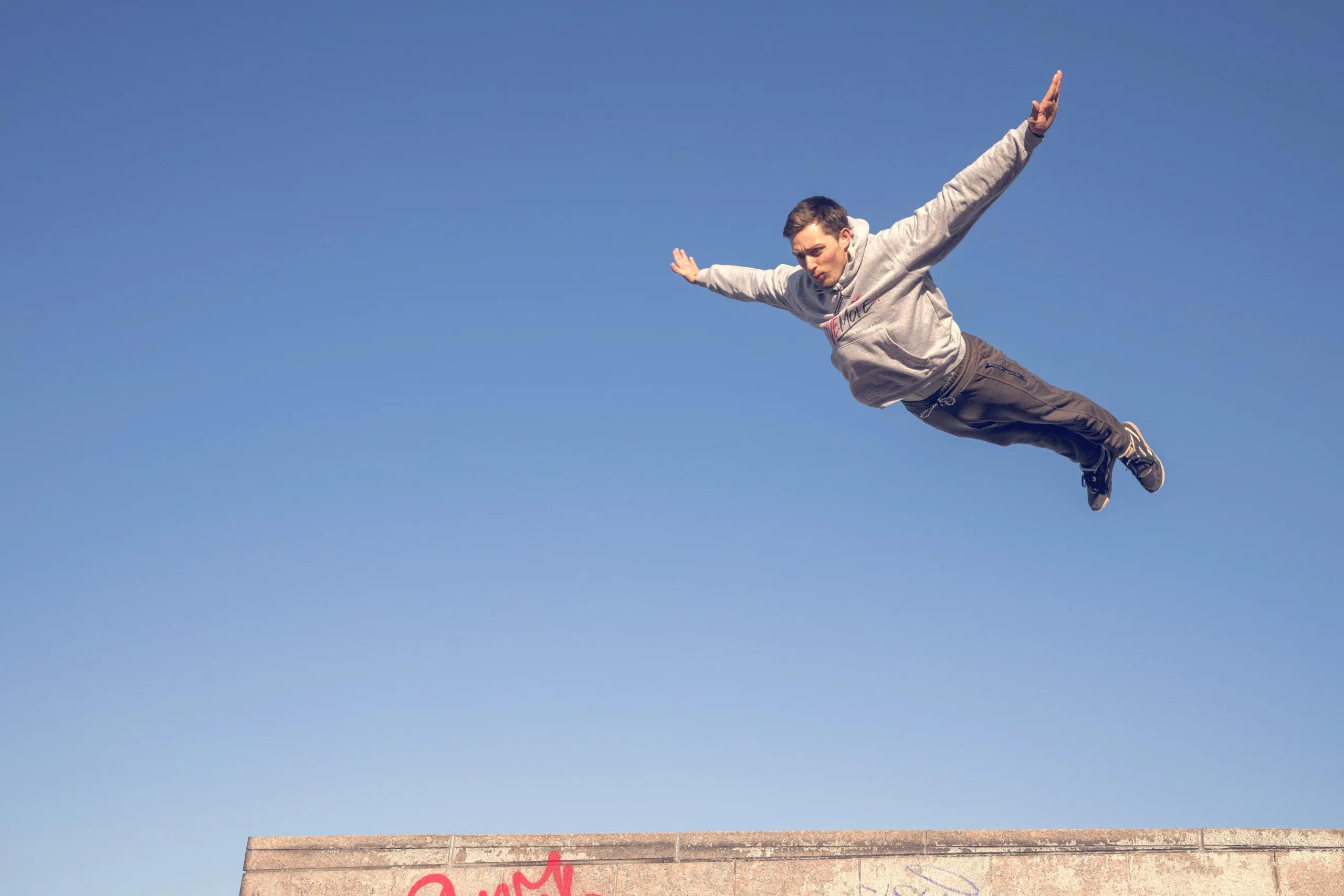 Parkour-Trainer von WEMOVE. im Flug über eine Mauerkante