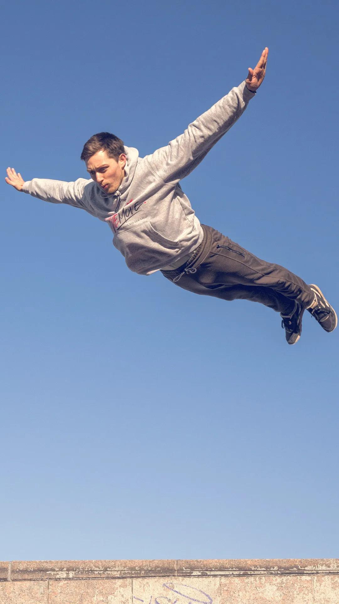 Parkour-Trainer von WEMOVE. im Flug über eine Mauerkante